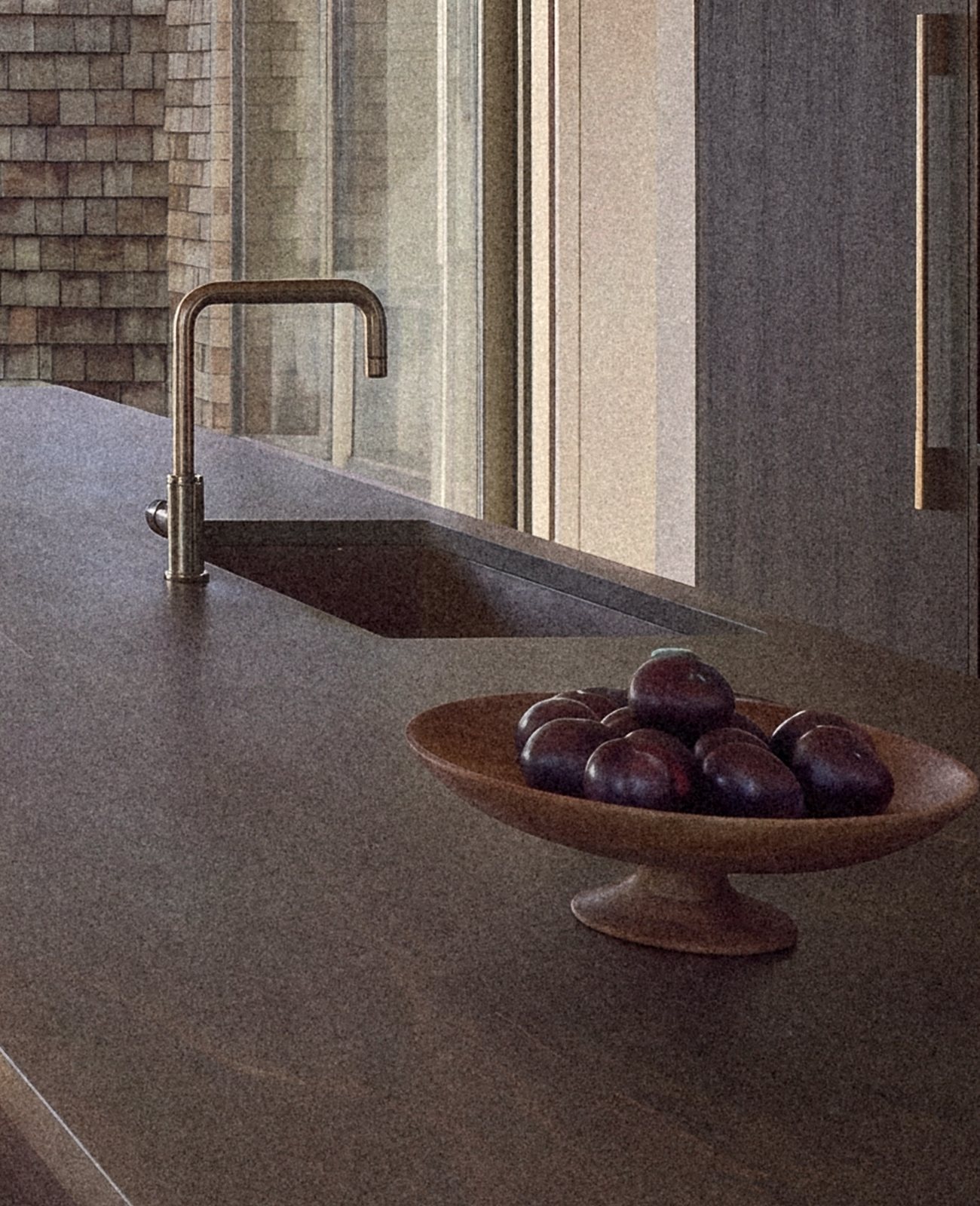 Rendering of the island counter with its tap and a wooden bowl of plums